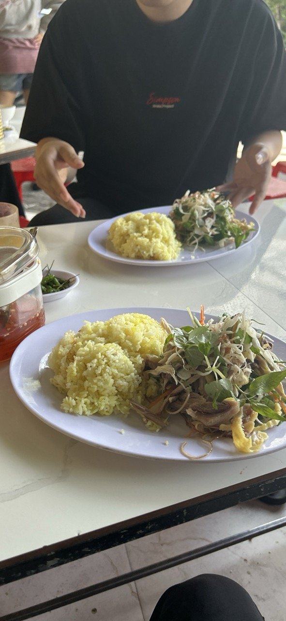 Cơm gà Hội An khác cơm gà Tam Kỳ và Đà Nẵng thế nào? 2 Hai phần cơm vàng ăn cùng gà xé và rau trong ảnh cơm gà Tam Kỳ